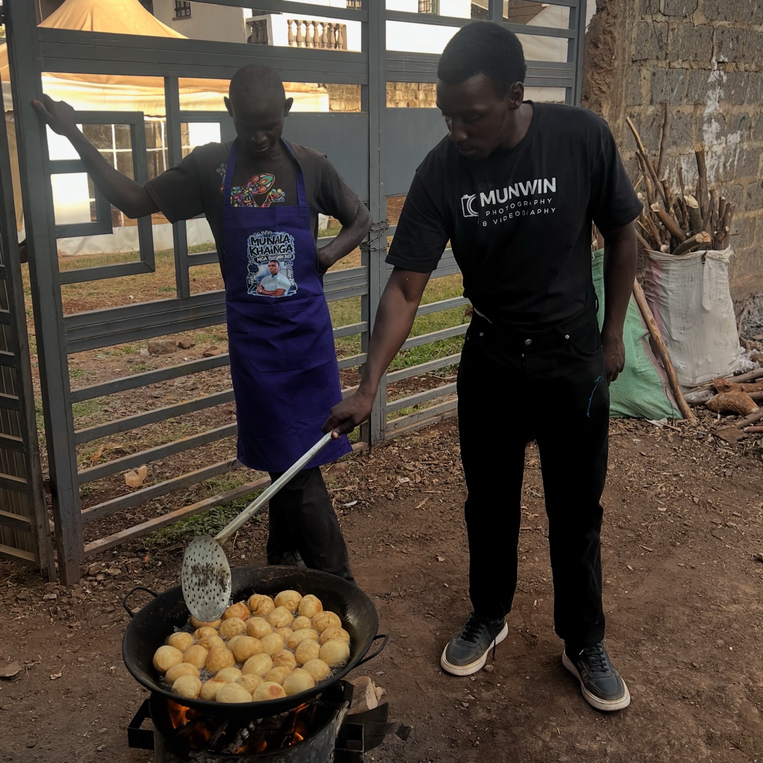 Munala learning from a local food trader while he cooks in Roysambu